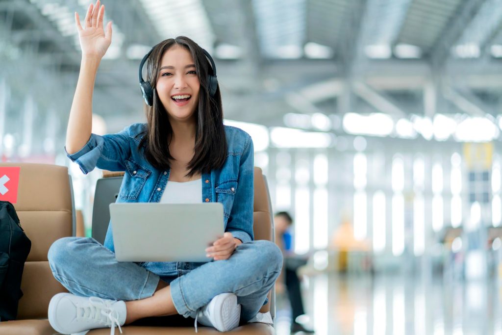 Traveler using laptop in airport terminal for Ascot airport taxi quotes